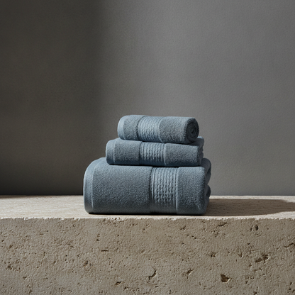 Stack of blue towels on a concrete surface with a gray background